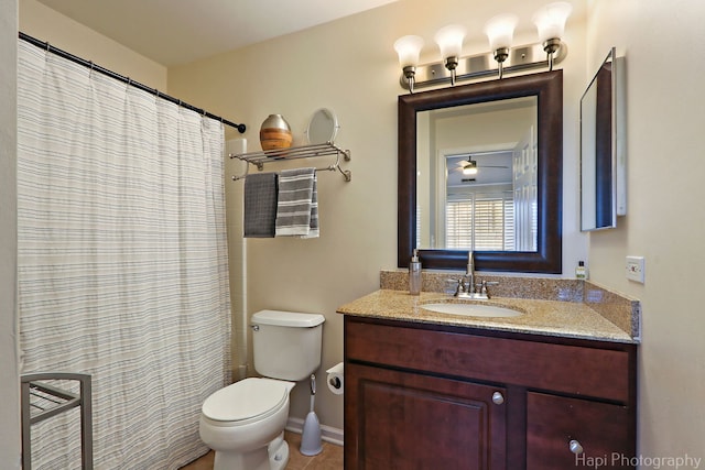 bathroom with vanity, a shower with shower curtain, toilet, and baseboards