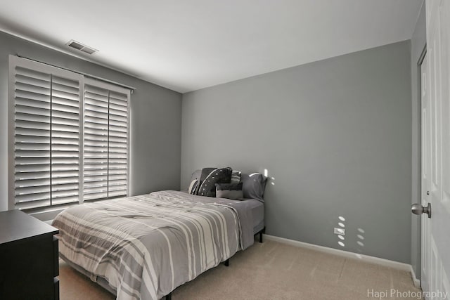 bedroom featuring light colored carpet and baseboards