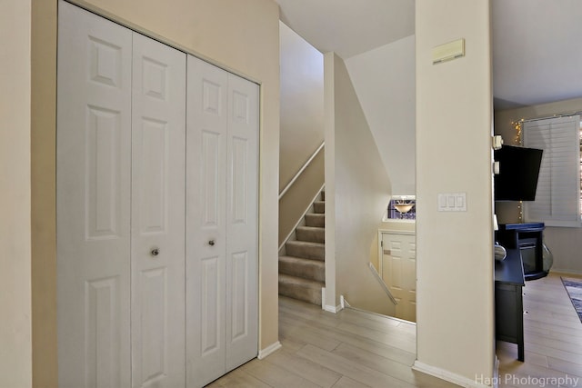 staircase featuring wood finished floors and baseboards