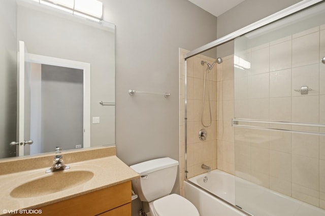 bathroom with vanity, toilet, and bath / shower combo with glass door