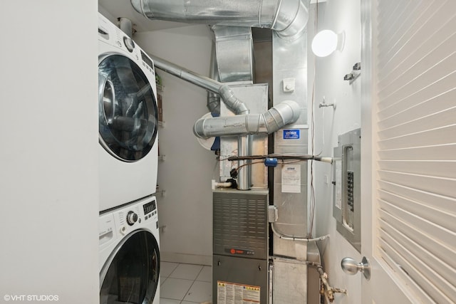 clothes washing area with laundry area, tile patterned floors, and stacked washing maching and dryer