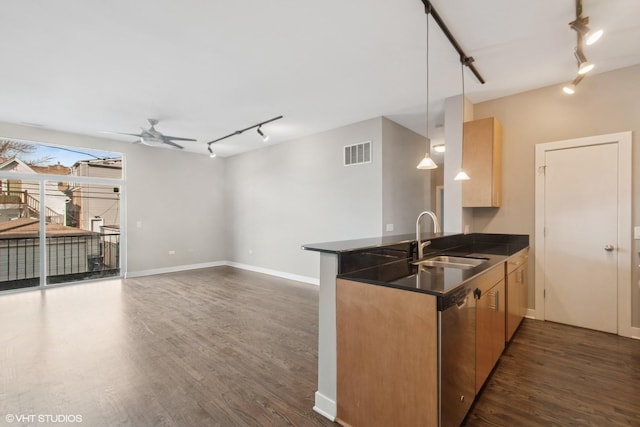 kitchen featuring visible vents, a peninsula, a sink, stainless steel dishwasher, and dark countertops