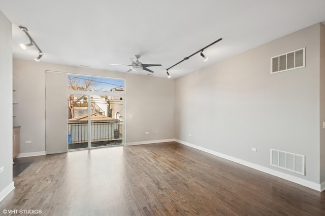 spare room with wood finished floors, visible vents, and ceiling fan