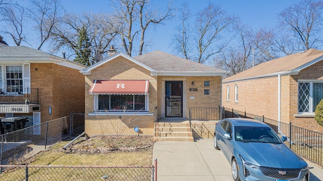 bungalow with brick siding and a fenced front yard