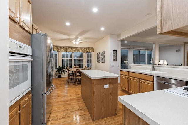 13536 Westridge Ct, Huntley, IL 60142 - kitchen featuring a center island, a sink, light wood-type flooring, ceiling fan, and appliances with stainless steel finishes