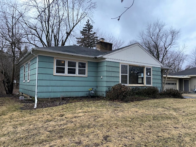 view of front of home with a front yard and a chimney