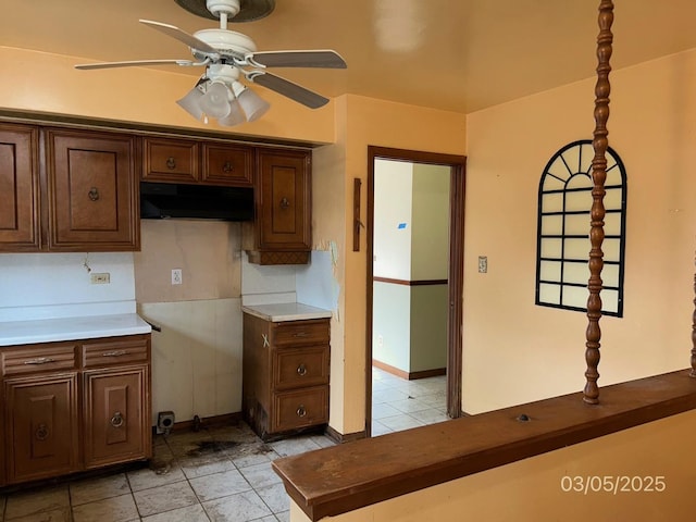 kitchen with light tile patterned floors, under cabinet range hood, and ceiling fan