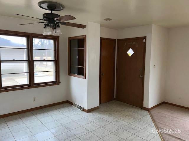 entrance foyer with baseboards, visible vents, and ceiling fan