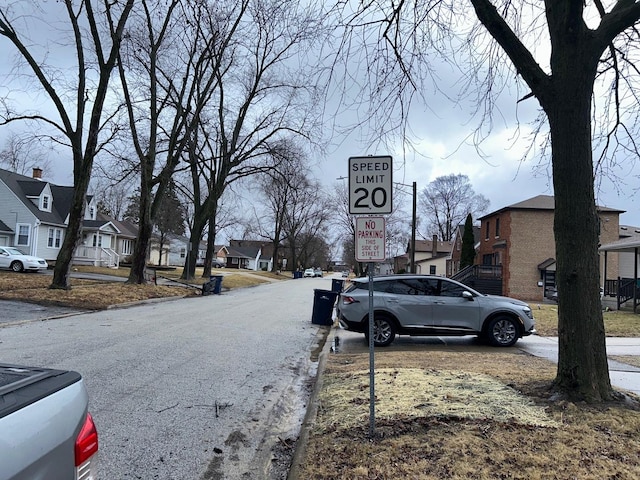 view of street with traffic signs, a residential view, and curbs