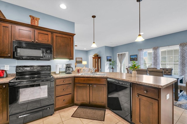 kitchen featuring black appliances, pendant lighting, a sink, a peninsula, and light tile patterned flooring