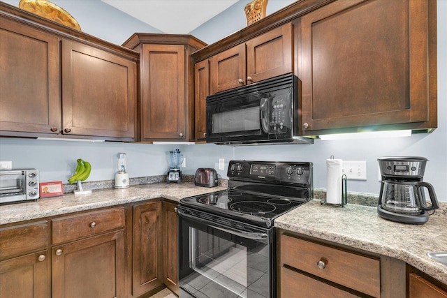 kitchen featuring a toaster, black appliances, and light stone countertops