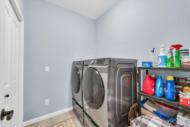 laundry area with tile patterned flooring, laundry area, baseboards, and separate washer and dryer