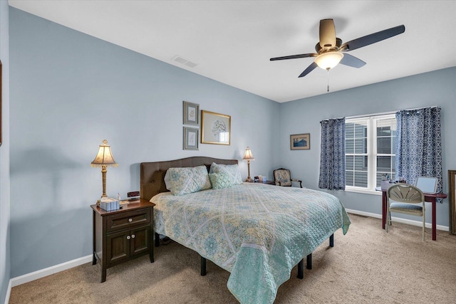 carpeted bedroom with visible vents, baseboards, and a ceiling fan