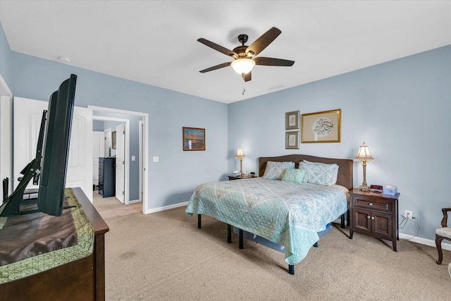 bedroom with a ceiling fan, baseboards, and light carpet