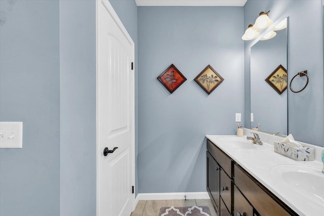 full bathroom with double vanity, tile patterned flooring, baseboards, and a sink