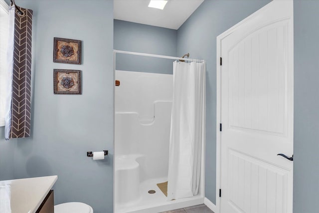 full bath featuring tile patterned flooring, a shower stall, vanity, and toilet