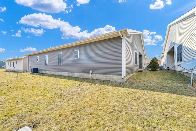 view of side of home with cooling unit and a yard