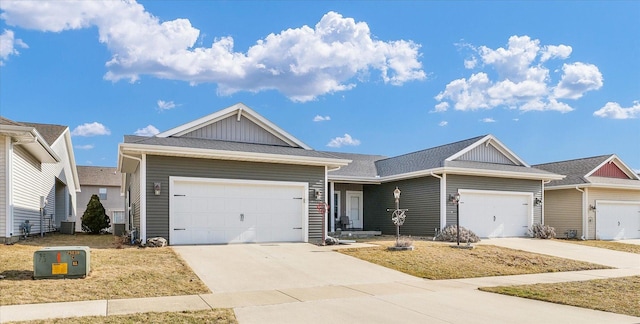 view of front of property featuring board and batten siding, a shingled roof, driveway, and a garage