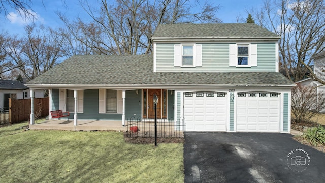 traditional-style house with a shingled roof, a front lawn, fence, aphalt driveway, and covered porch