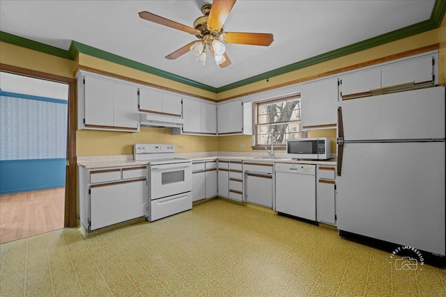 kitchen with white appliances, light floors, ornamental molding, light countertops, and under cabinet range hood