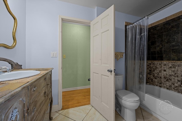 bathroom featuring tile patterned flooring, baseboards, toilet, shower / tub combo with curtain, and vanity