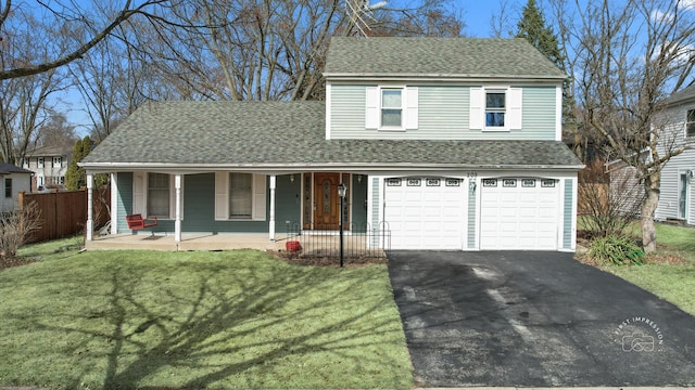 traditional home featuring covered porch, driveway, roof with shingles, and fence