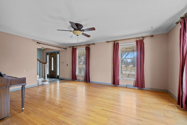 unfurnished living room with ceiling fan, stairway, ornamental molding, and light wood finished floors