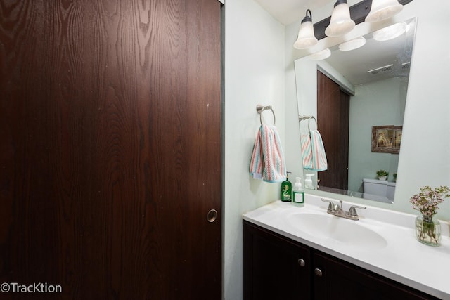 bathroom with visible vents, toilet, and vanity