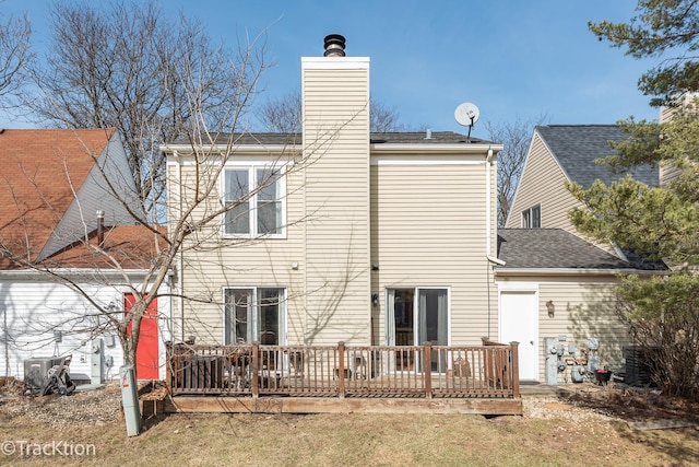 rear view of property with a chimney and a deck