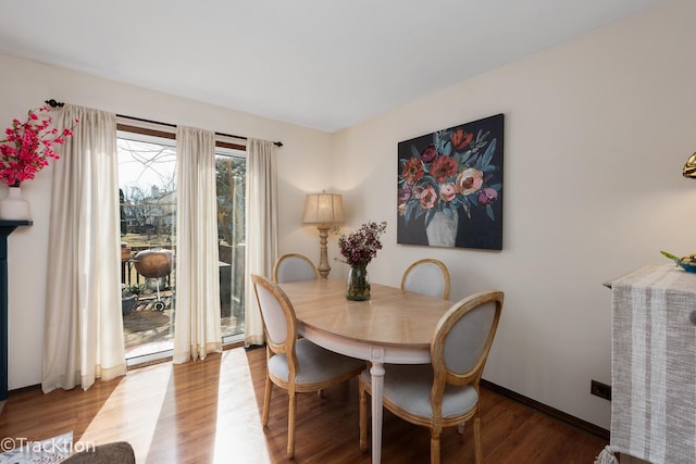 dining space featuring wood finished floors and baseboards