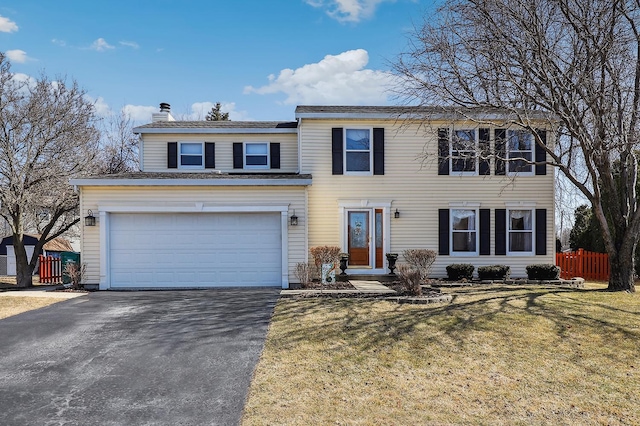 view of front of house featuring a front lawn, driveway, fence, a garage, and a chimney