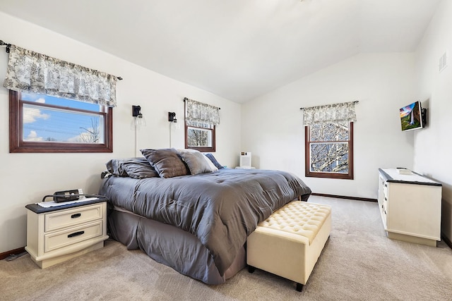 bedroom featuring lofted ceiling, visible vents, baseboards, and light carpet