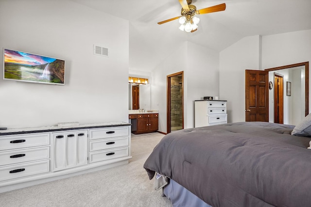 bedroom with visible vents, ensuite bathroom, a sink, lofted ceiling, and light colored carpet