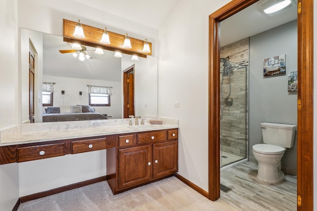 ensuite bathroom featuring baseboards, a ceiling fan, a shower stall, and ensuite bathroom