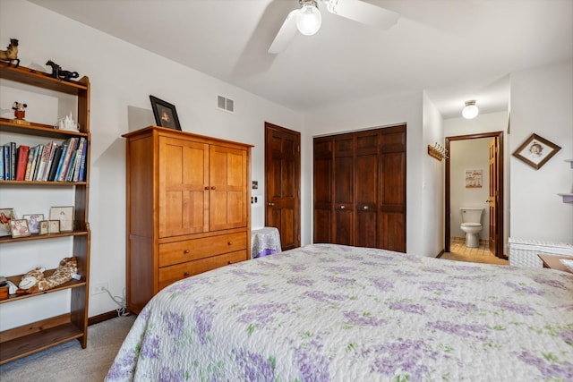 carpeted bedroom featuring ceiling fan, baseboards, visible vents, and connected bathroom