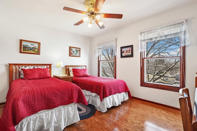 bedroom with baseboards, wood finished floors, and a ceiling fan