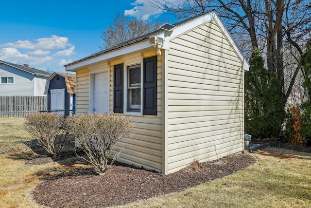 view of home's exterior with an outdoor structure and fence