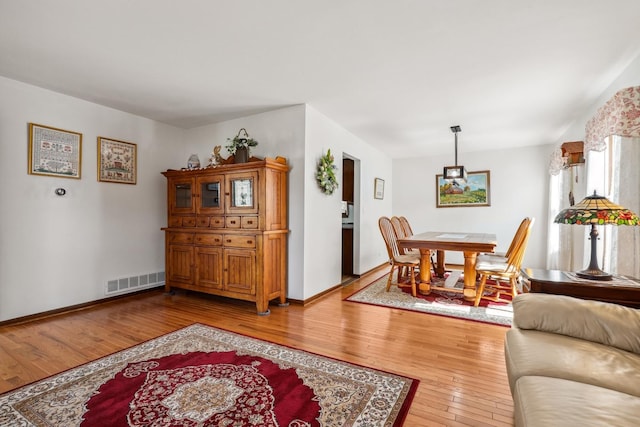 dining room with visible vents, light wood-type flooring, and baseboards