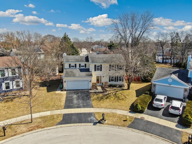 view of front of property featuring a front yard, a chimney, driveway, and roof with shingles