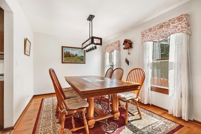 dining room featuring baseboards and light wood-type flooring