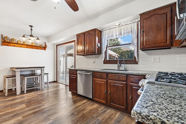 kitchen with a ceiling fan, a sink, dark wood-type flooring, appliances with stainless steel finishes, and backsplash