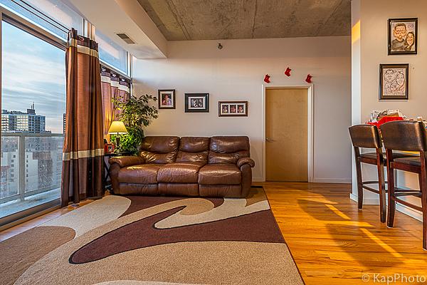 living area featuring wood finished floors, a healthy amount of sunlight, and visible vents