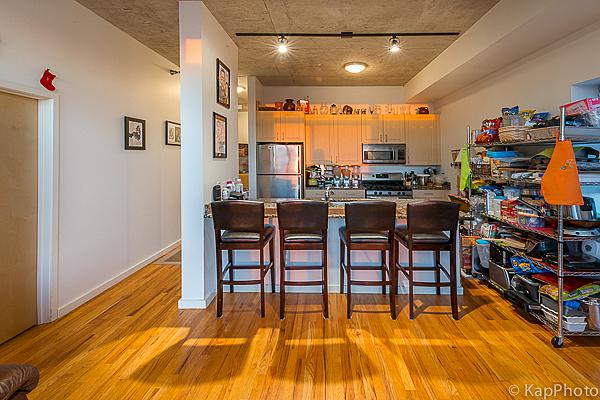 kitchen with baseboards, a breakfast bar area, appliances with stainless steel finishes, a peninsula, and light wood-style floors