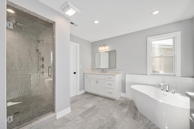 full bathroom with vanity, visible vents, baseboards, a freestanding tub, and a stall shower