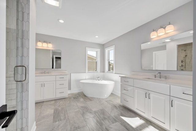 bathroom with a sink, a soaking tub, two vanities, and a stall shower