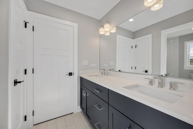 full bathroom with double vanity and a sink