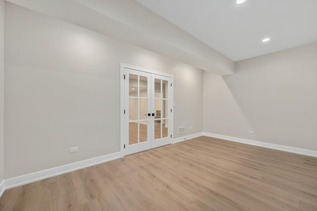 spare room featuring french doors, baseboards, visible vents, and light wood finished floors