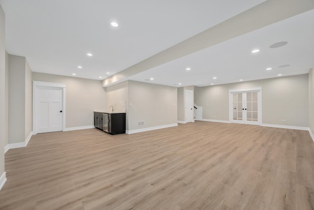 below grade area with light wood-style flooring, recessed lighting, baseboards, and a sink