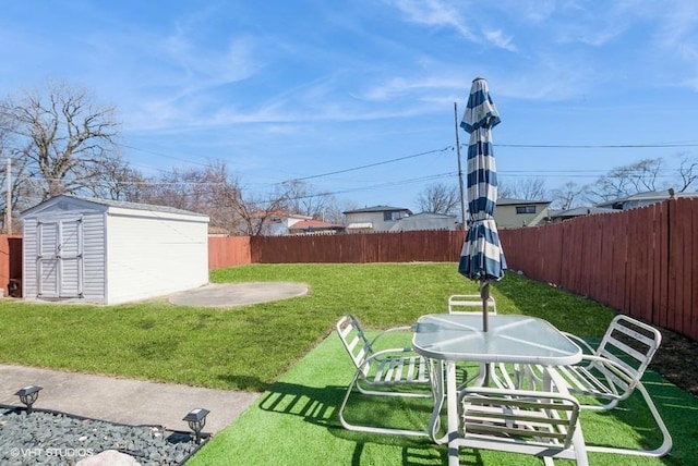 view of yard with an outbuilding, a storage unit, and a fenced backyard