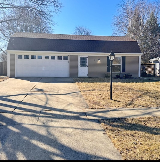 colonial inspired home with driveway, an attached garage, roof with shingles, and fence